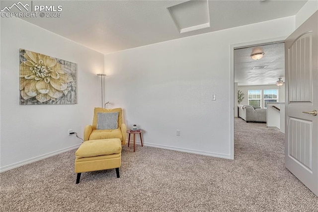 living area featuring carpet, baseboards, and attic access