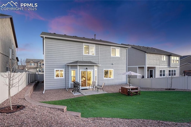 rear view of house with a patio area, a yard, and a fenced backyard