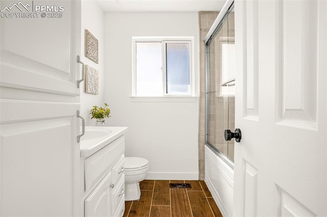 bathroom with toilet, vanity, baseboards, combined bath / shower with glass door, and wood tiled floor