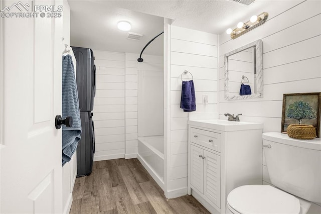 full bath featuring visible vents, toilet, wood finished floors, a textured ceiling, and vanity