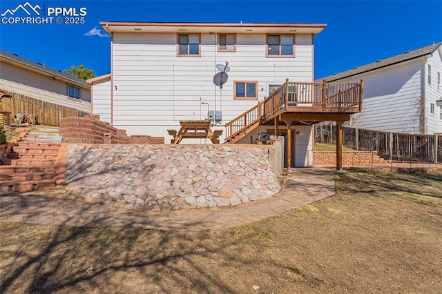 back of house featuring stairs, fence, and a deck