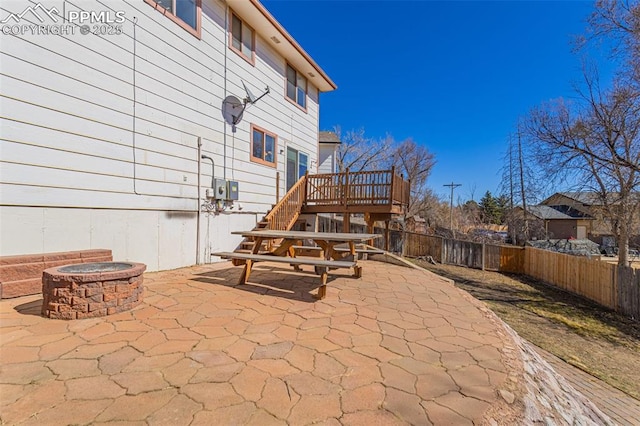 view of patio / terrace featuring an outdoor fire pit, a fenced backyard, stairway, and a wooden deck