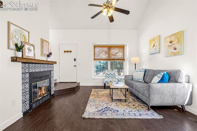 living room featuring a tiled fireplace, wood finished floors, and baseboards