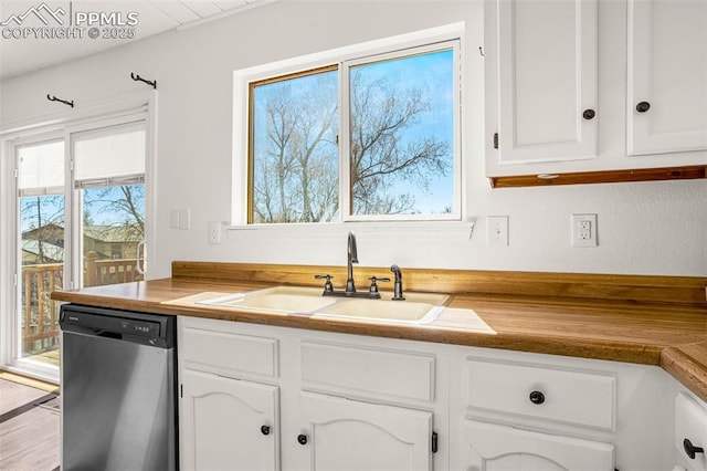 kitchen with a sink, white cabinets, and dishwasher