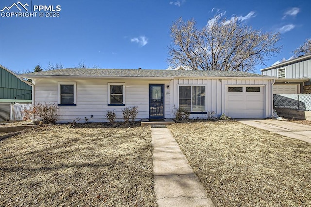 single story home with concrete driveway, board and batten siding, an attached garage, and fence