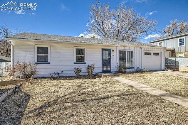 single story home featuring board and batten siding, concrete driveway, fence, and a garage