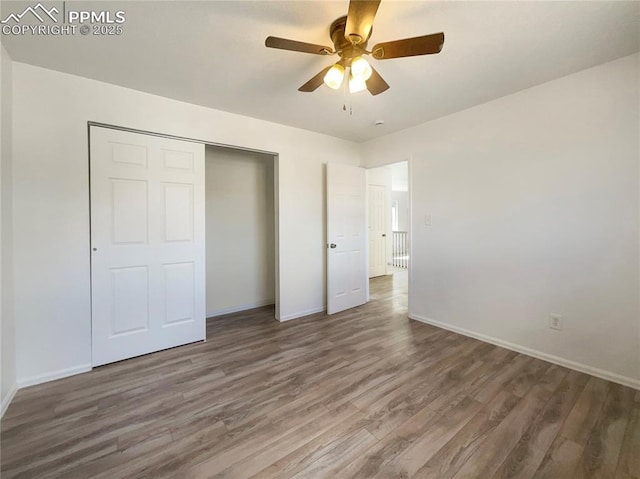 unfurnished bedroom featuring a closet, baseboards, and wood finished floors