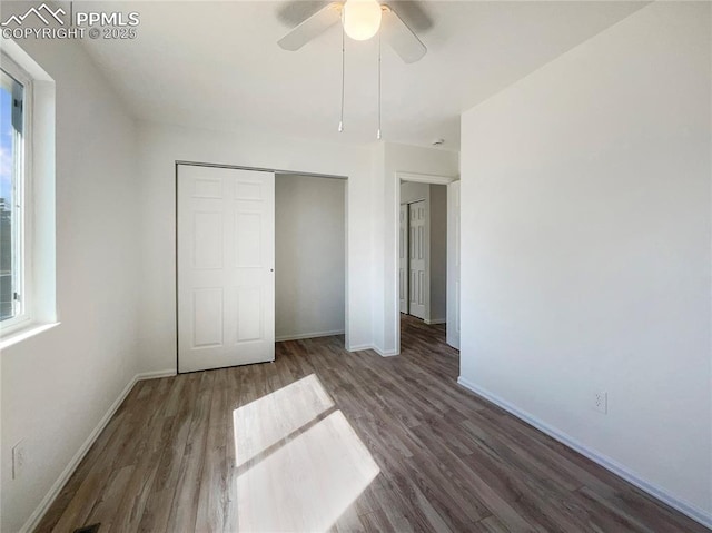 unfurnished bedroom featuring a closet, wood finished floors, a ceiling fan, and baseboards