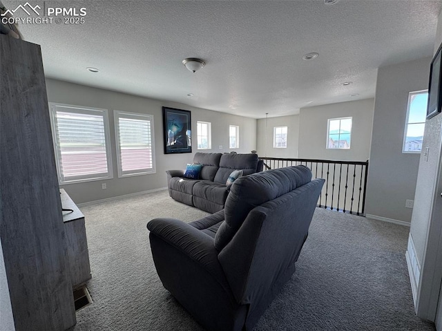 carpeted living room featuring a textured ceiling and baseboards