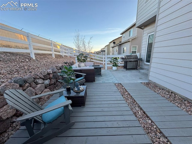 wooden deck with a fenced backyard, an outdoor living space, a patio, and grilling area