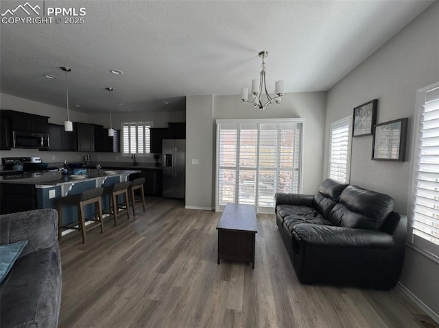 living area with a textured ceiling, wood finished floors, and baseboards