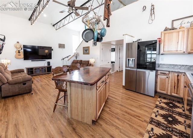 kitchen featuring light wood-type flooring, light brown cabinets, open floor plan, and a ceiling fan