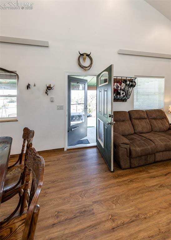 foyer entrance with vaulted ceiling and wood finished floors