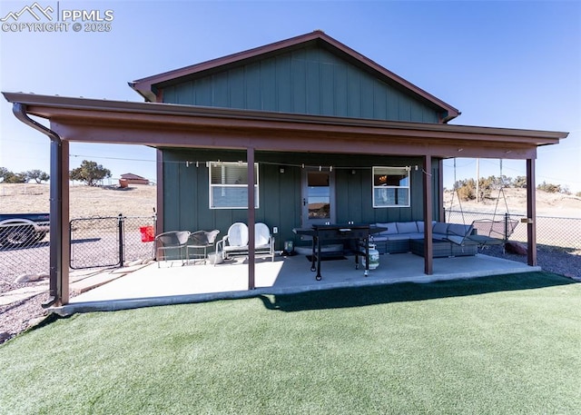 back of property with board and batten siding, fence, a patio, and an outdoor hangout area