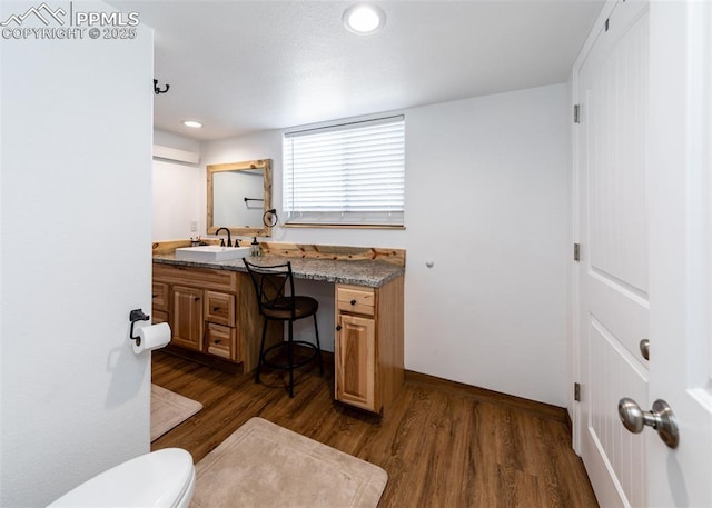 interior space with dark wood finished floors, a sink, baseboards, and recessed lighting