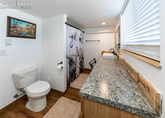 bathroom featuring wood finished floors, vanity, toilet, and baseboards