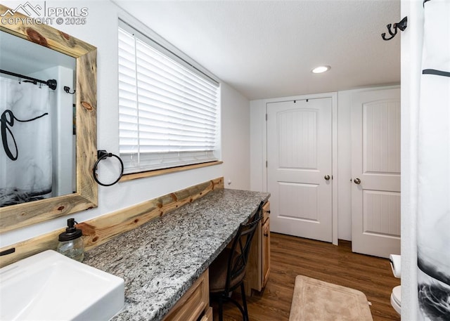 interior space featuring toilet, a shower with curtain, wood finished floors, a sink, and recessed lighting