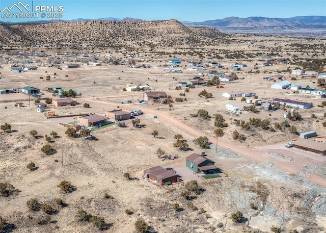 birds eye view of property featuring a desert view, a rural view, and a mountain view