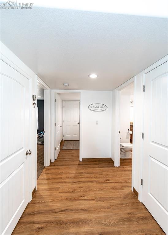 hall featuring light wood finished floors and recessed lighting