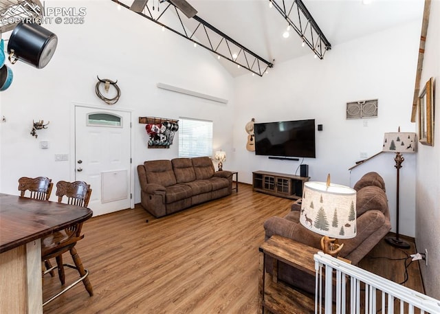 living room featuring high vaulted ceiling and light wood-style floors