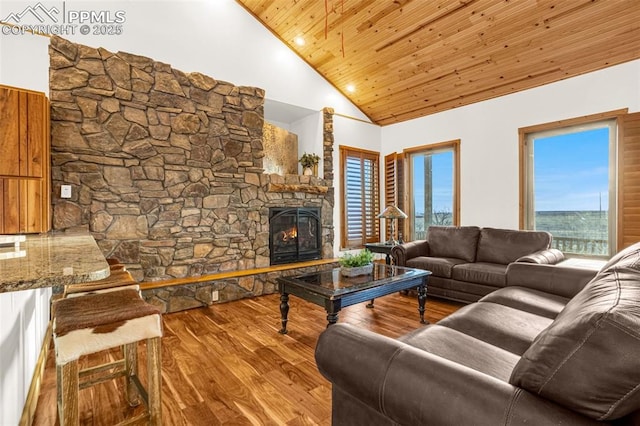 living room featuring wooden ceiling, a fireplace, high vaulted ceiling, and wood finished floors