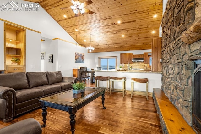 living area with built in features, a ceiling fan, wooden ceiling, wood finished floors, and high vaulted ceiling