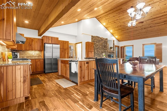 kitchen with brown cabinets, appliances with stainless steel finishes, wood ceiling, wood finished floors, and under cabinet range hood