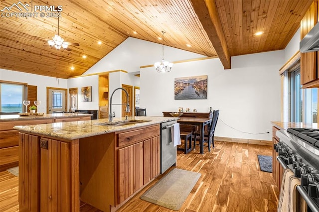 kitchen with appliances with stainless steel finishes, a sink, a center island with sink, and brown cabinets