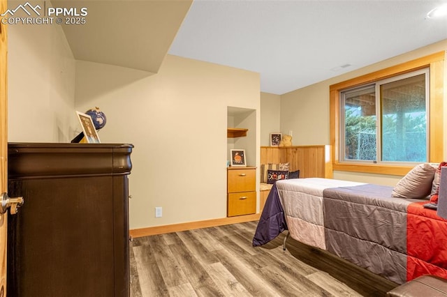 bedroom with wood finished floors and baseboards