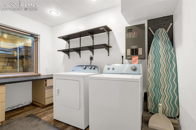 clothes washing area featuring dark wood-type flooring, laundry area, and washing machine and clothes dryer