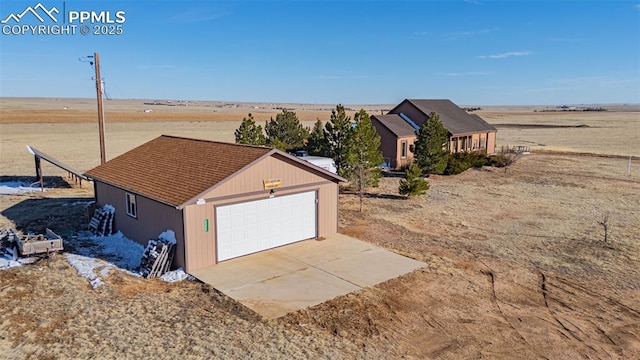 view of front of home with driveway, a garage, and an outbuilding