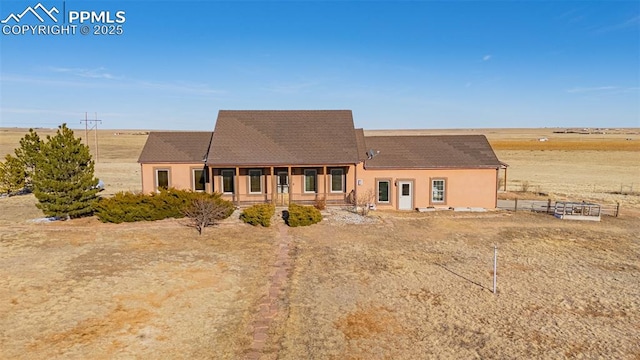 back of property with covered porch and stucco siding