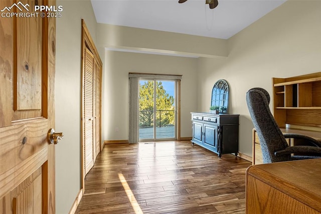 office area with dark wood-type flooring, baseboards, and a ceiling fan