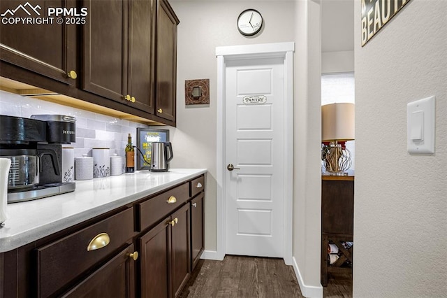 bar featuring baseboards, dark wood finished floors, and decorative backsplash