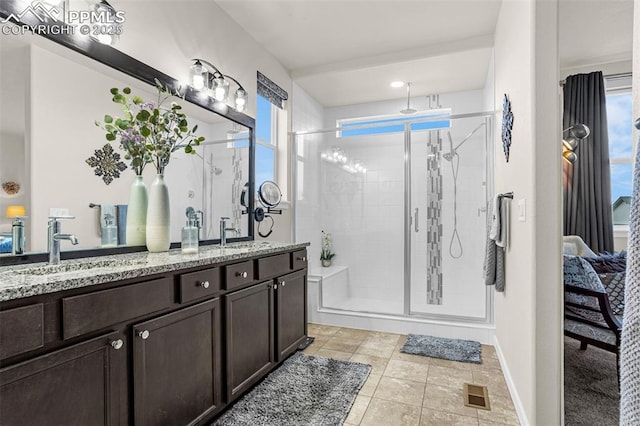 full bath with visible vents, a sink, a shower stall, and double vanity