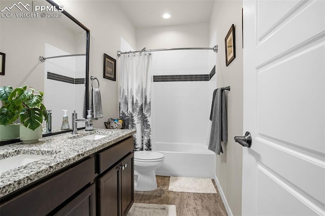 bathroom with double vanity, shower / tub combo, toilet, wood finished floors, and a sink