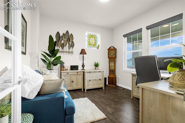 home office with dark wood-type flooring and baseboards