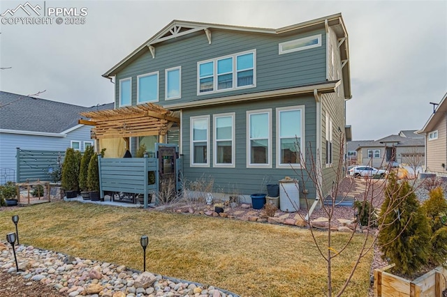 rear view of house with a lawn and a pergola