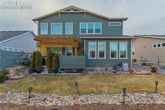 rear view of property featuring a yard, a patio area, fence, and a pergola