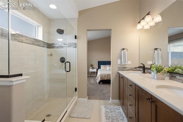 ensuite bathroom with double vanity, a shower stall, a sink, and ensuite bathroom