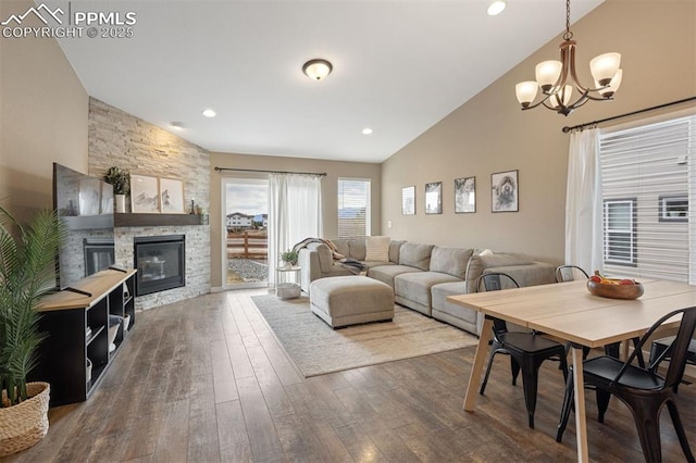 living room with high vaulted ceiling, recessed lighting, a stone fireplace, and hardwood / wood-style floors