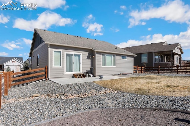 view of front of property with a fenced backyard, roof with shingles, and a patio