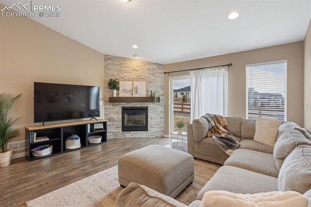 living room with lofted ceiling, a fireplace, plenty of natural light, and wood finished floors