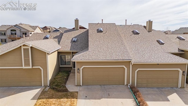 townhome / multi-family property with a chimney, concrete driveway, and roof with shingles