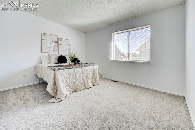 carpeted bedroom featuring visible vents, a textured ceiling, and baseboards