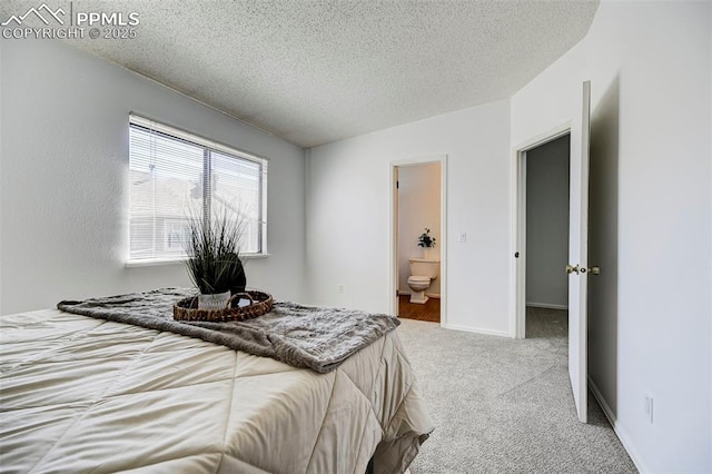 bedroom featuring connected bathroom, carpet floors, a textured ceiling, and baseboards