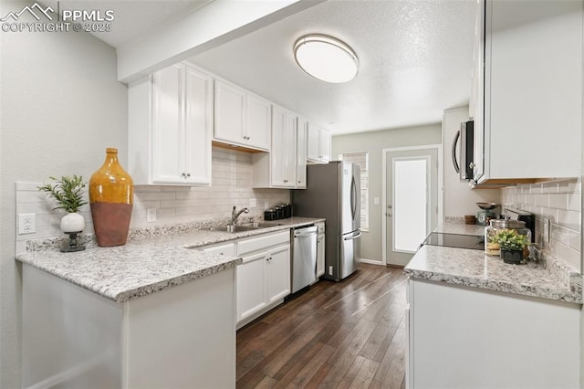 kitchen featuring appliances with stainless steel finishes, dark wood-style flooring, a sink, and white cabinetry
