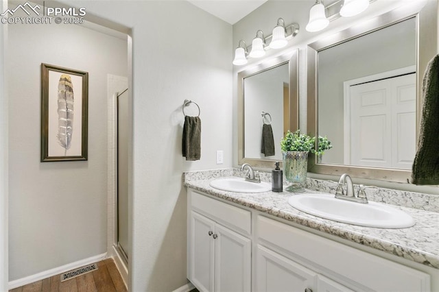 full bath with double vanity, a stall shower, visible vents, and a sink