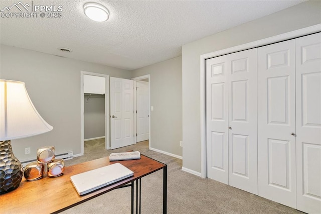 office area featuring visible vents, baseboard heating, light carpet, a textured ceiling, and baseboards