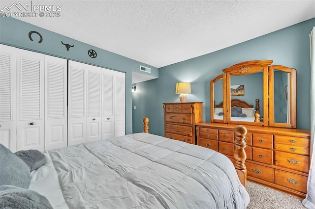 bedroom with a textured ceiling, a closet, carpet, and visible vents